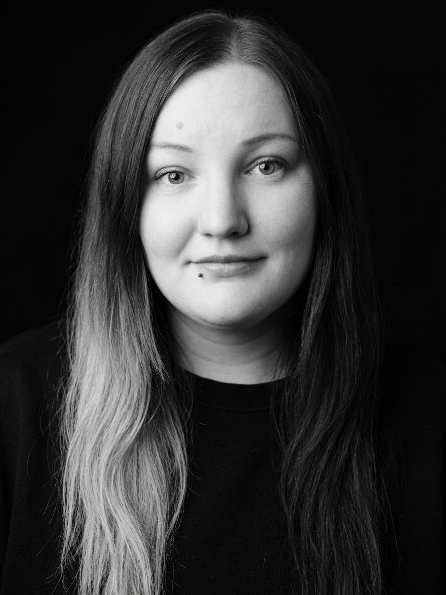 Black and white portrait of a person with long hair against a dark background